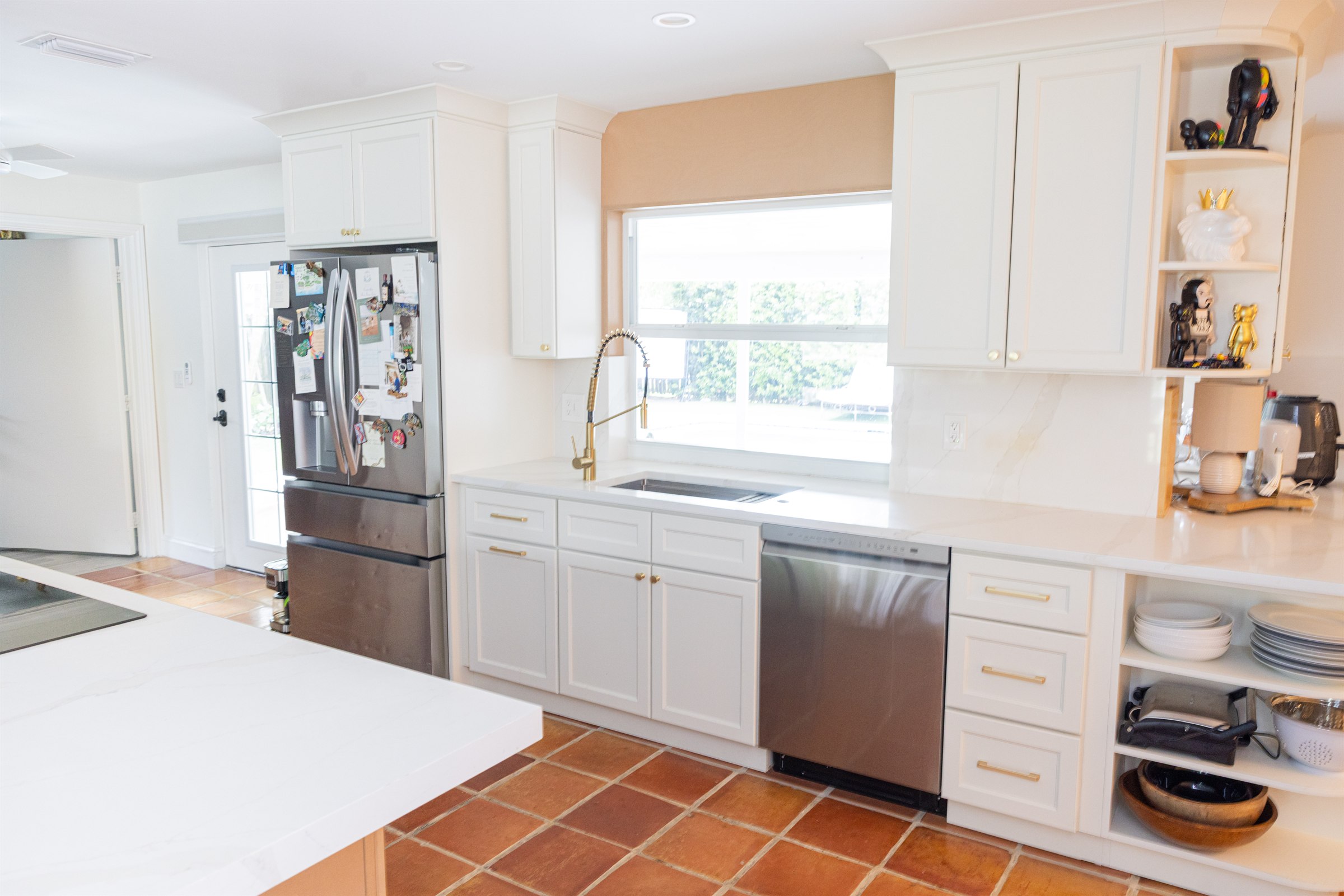 Kitchen with open under-sink clearance, side-by-side dishwasher, and window above the sink