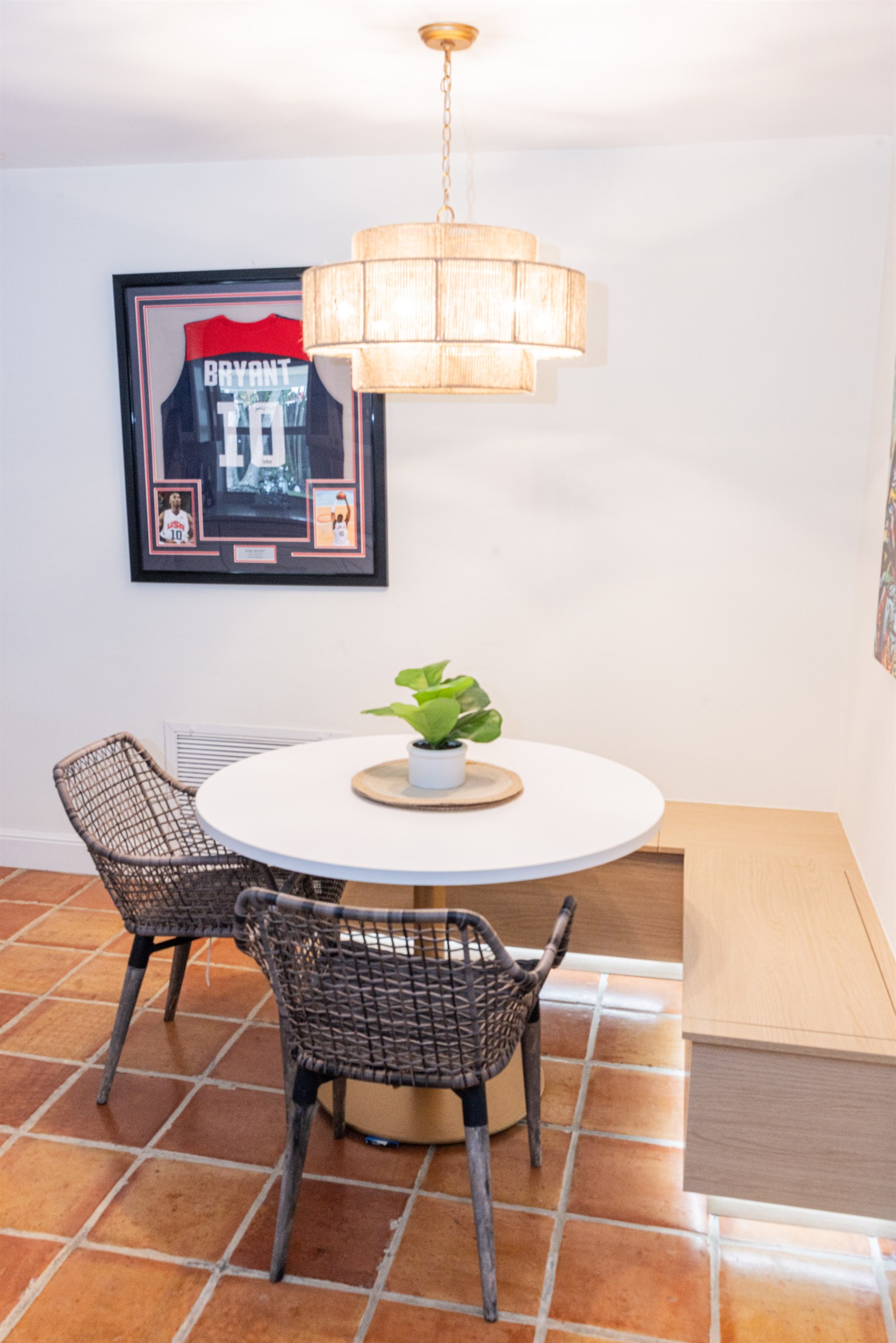 Breakfast nook with round table, woven chairs, and a low bench with easy-access hidden storage