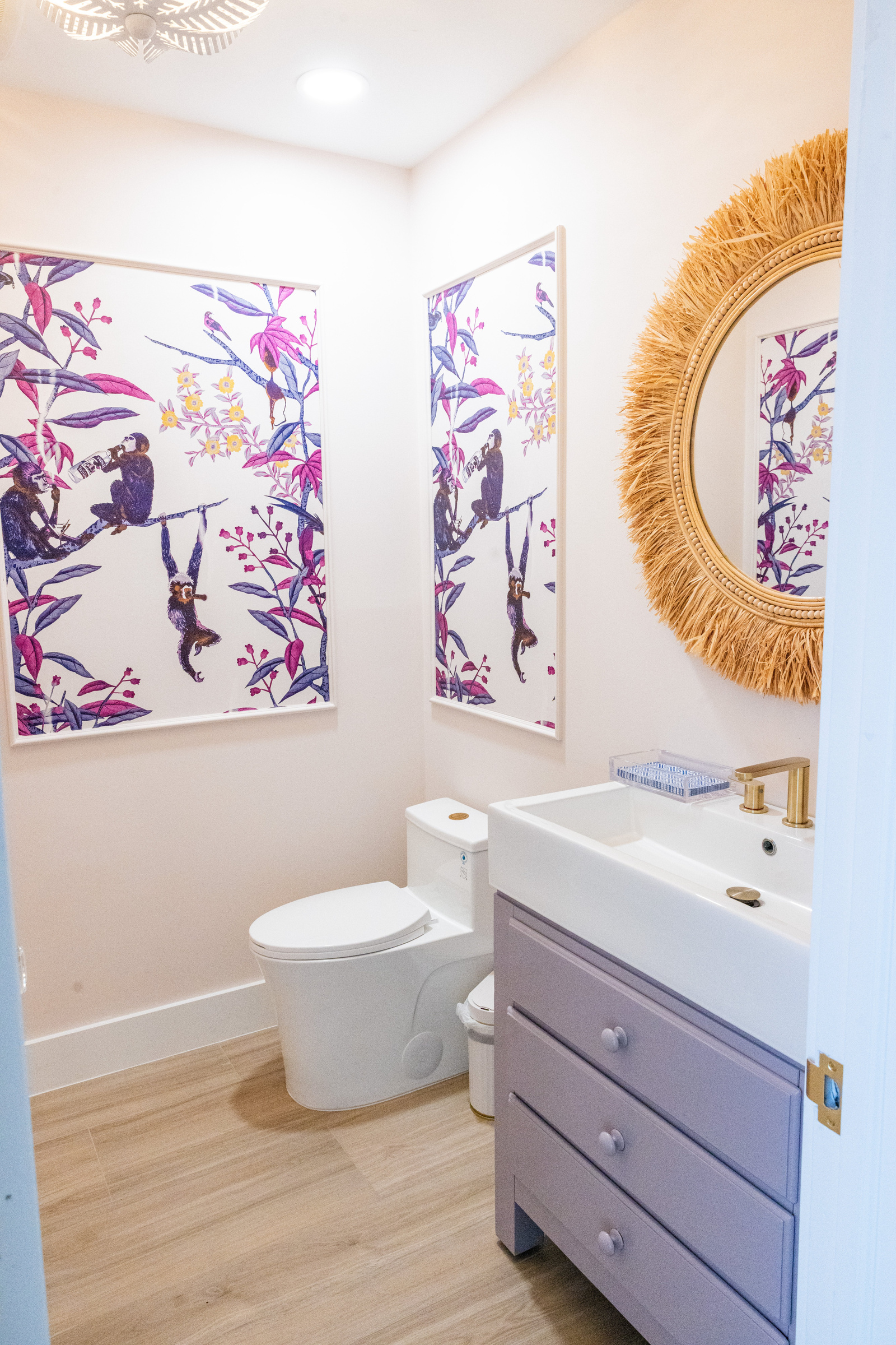 Powder room with nature wallpaper and wood-tone vanity