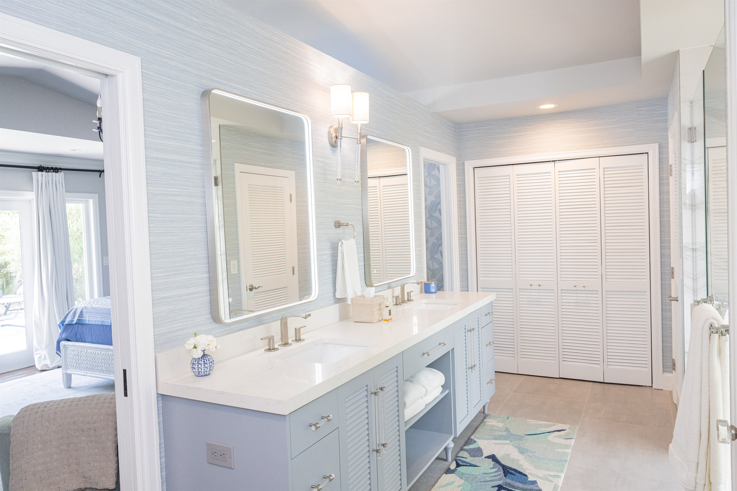 Louvered closets and blue vanity opening toward the bedroom and monkey-print hallway