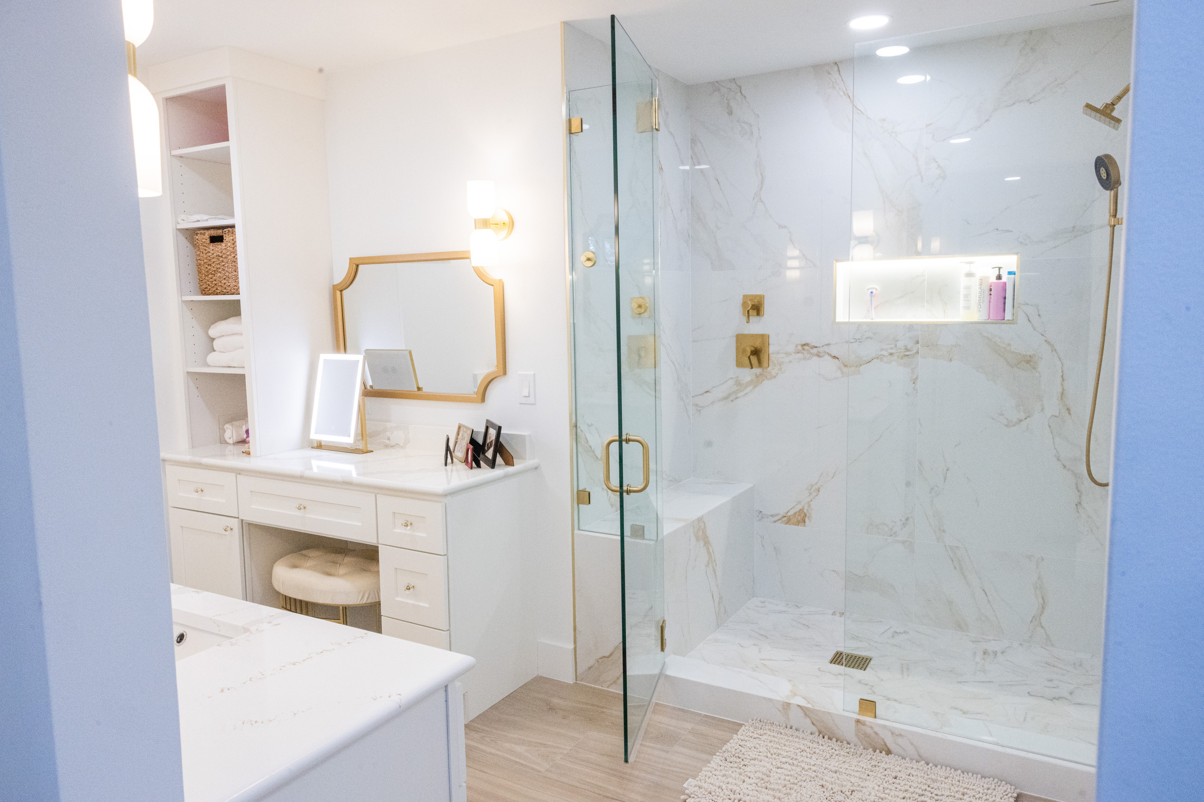 Master bath makeup vanity and floor-to-ceiling marble shower enclosure