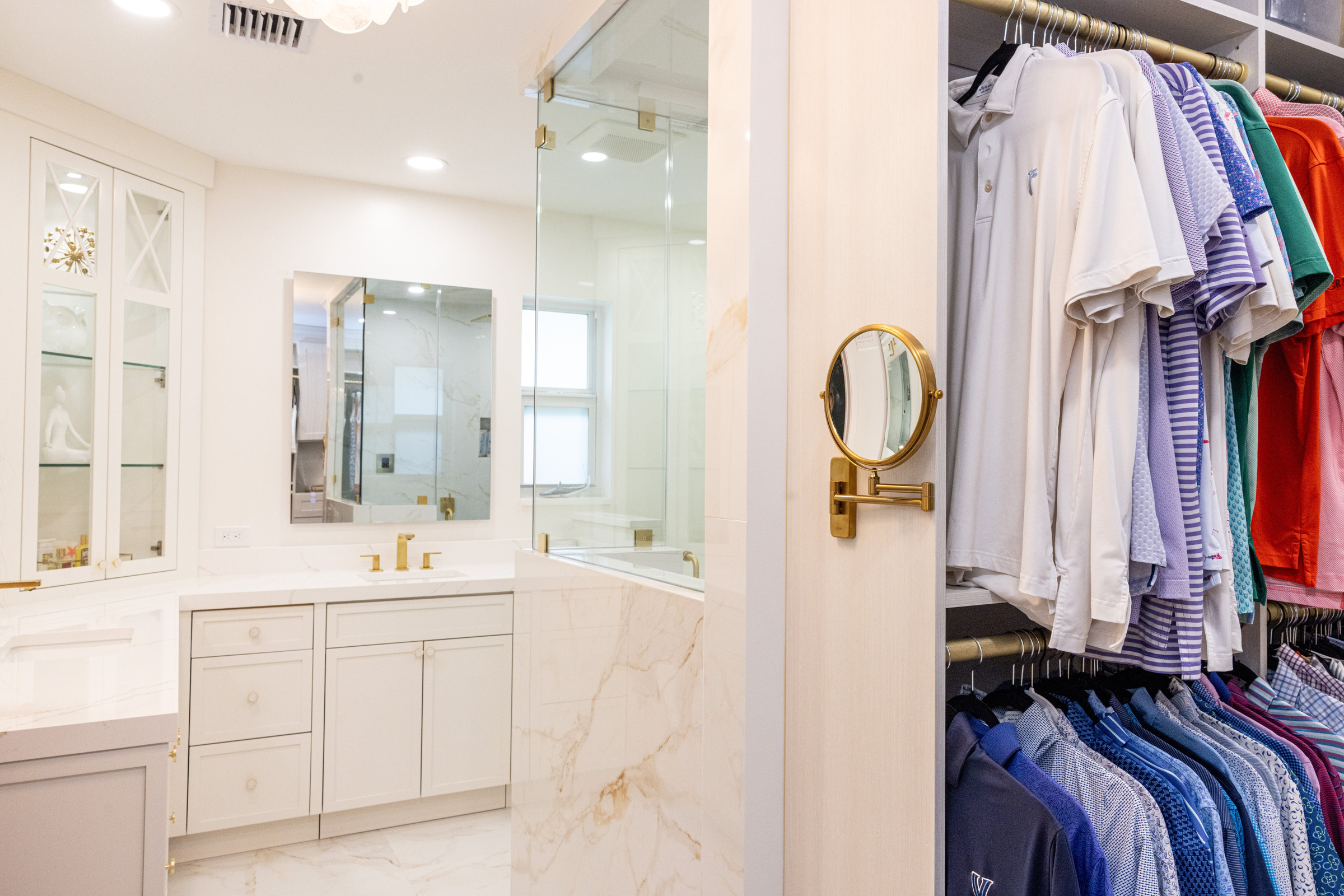 Master bath with closet view, marble tile and gold hardware detail