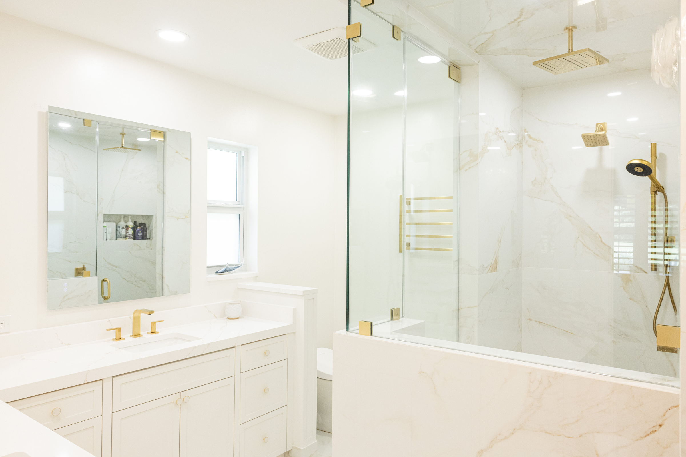 Master bath single vanity with marble surround and glass shower