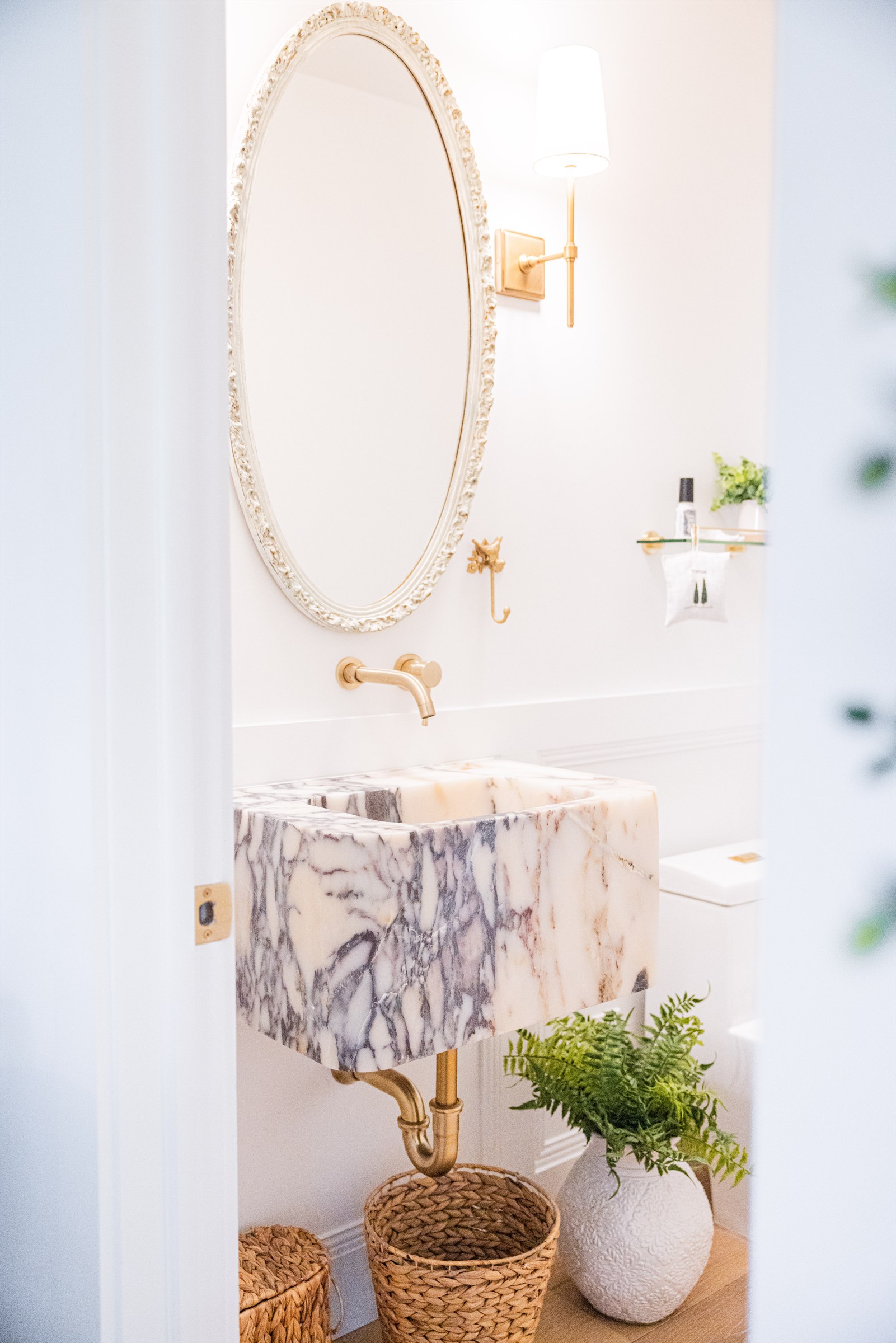 Corner vanity with glass-front cabinetry and view into the marble walk-in shower