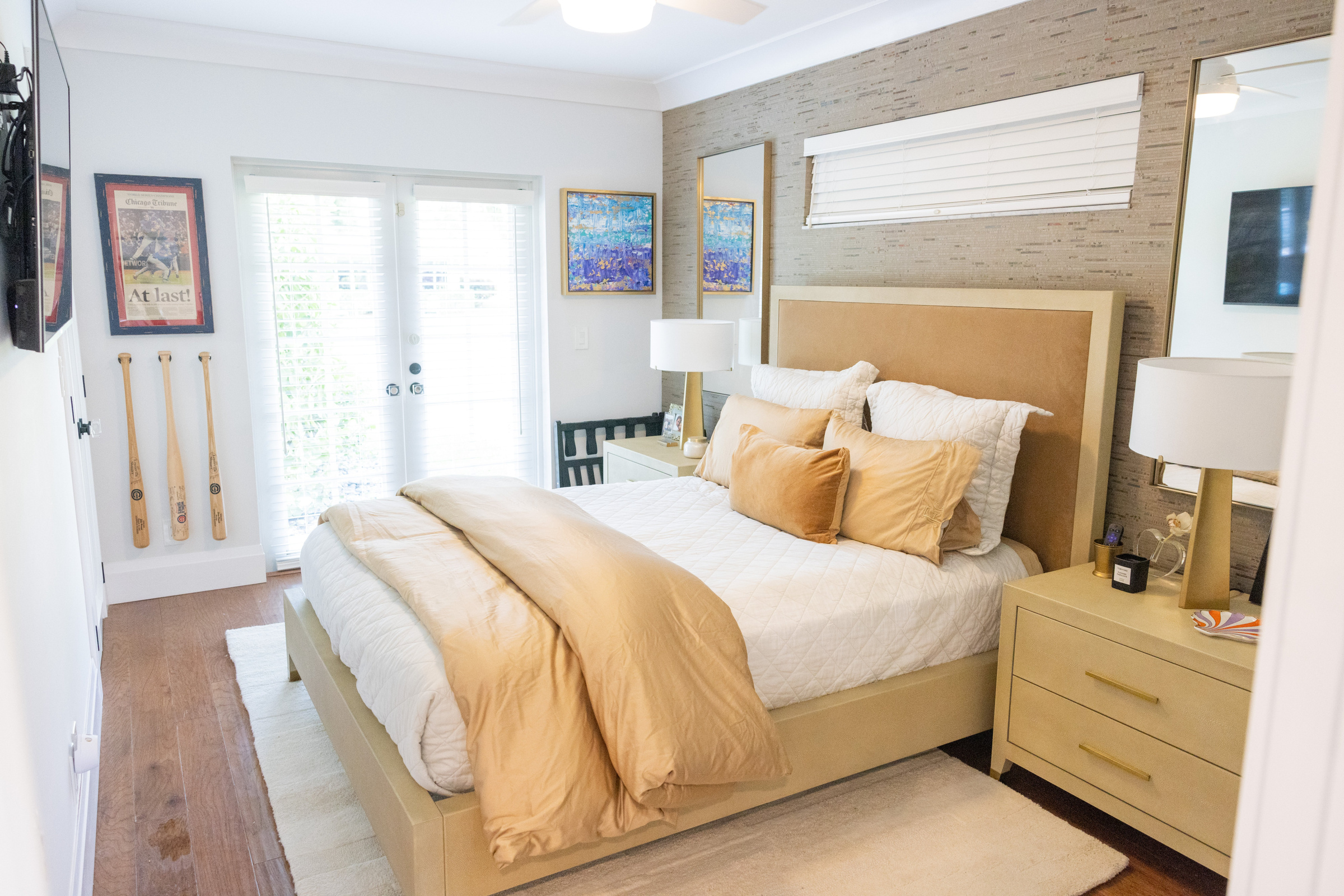 Twin guest bedroom with textured wall panels and gray upholstered headboards