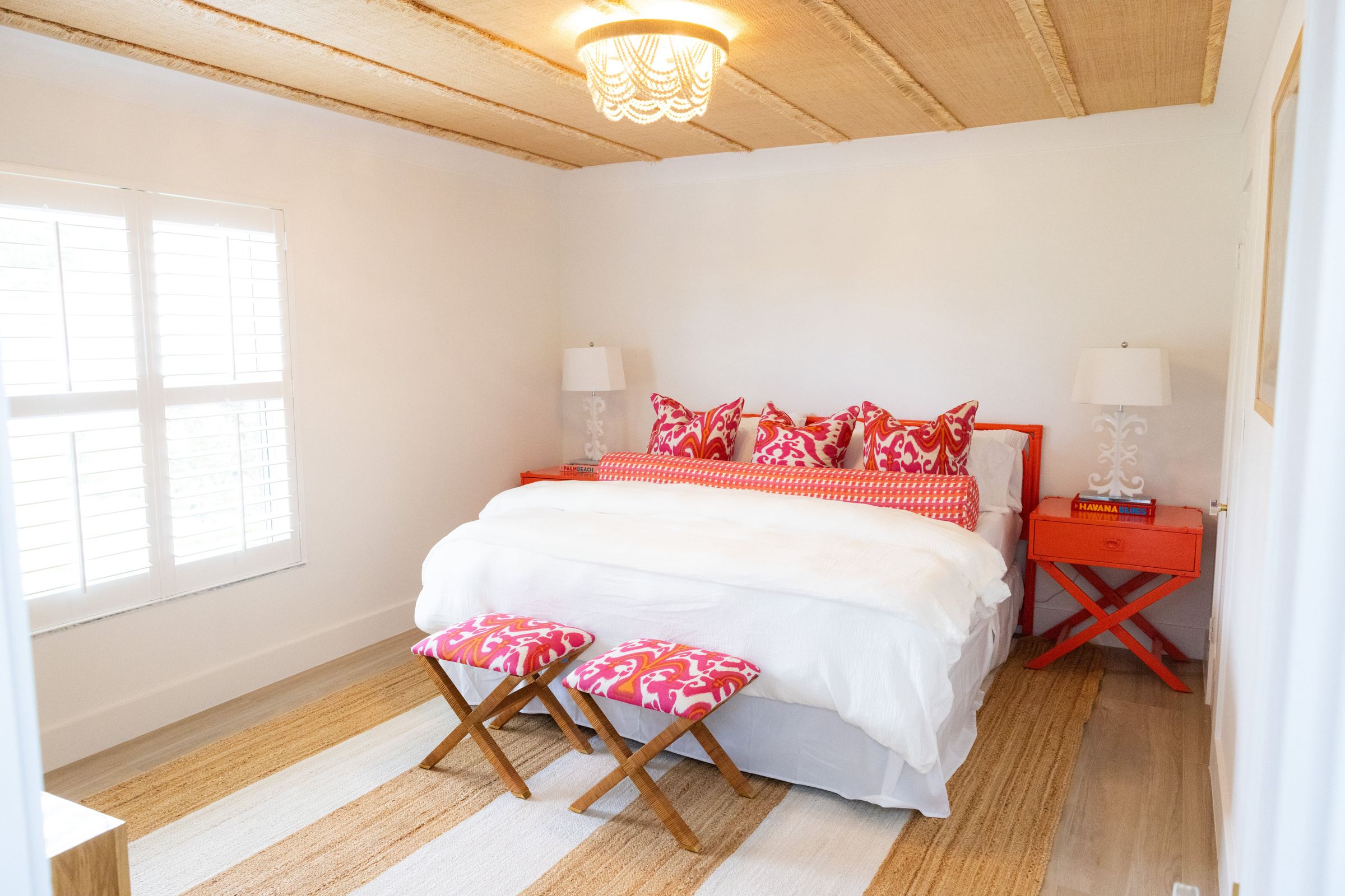 Guest bedroom with grasscloth accent wall and gold headboard
