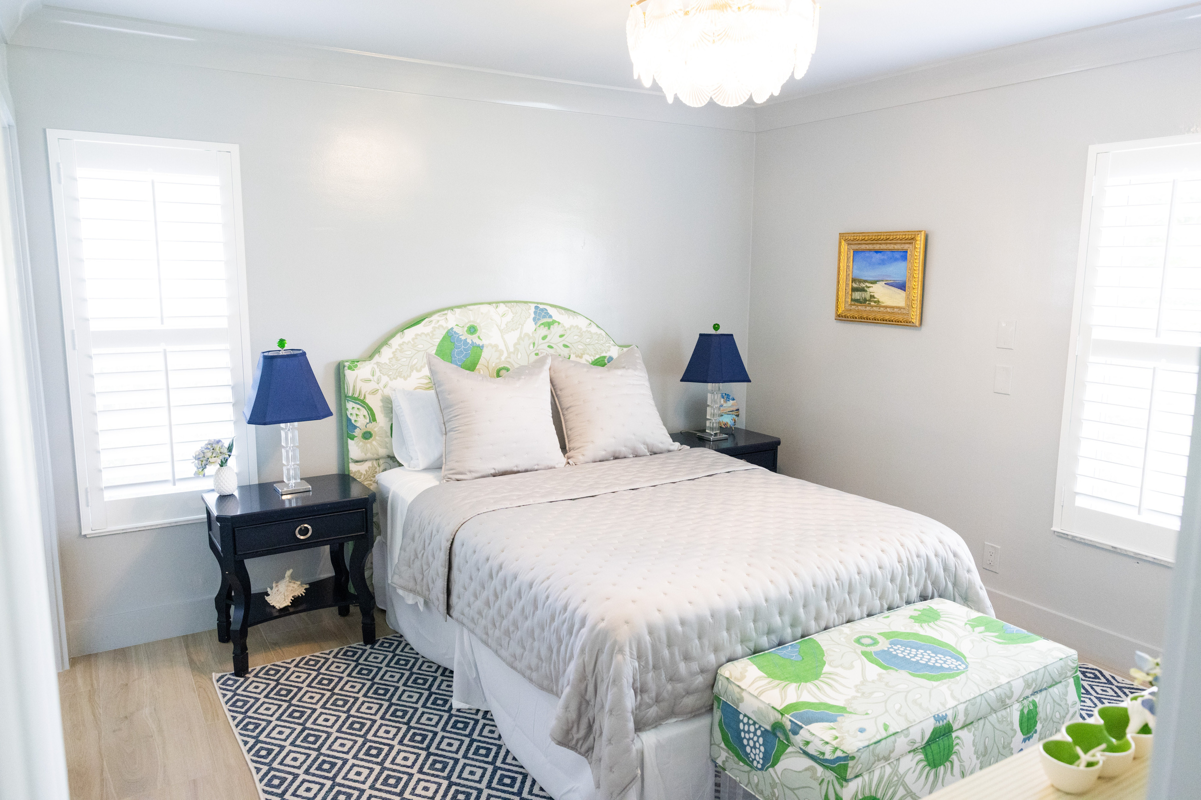 Guest bedroom with full view including personal art collection and French doors