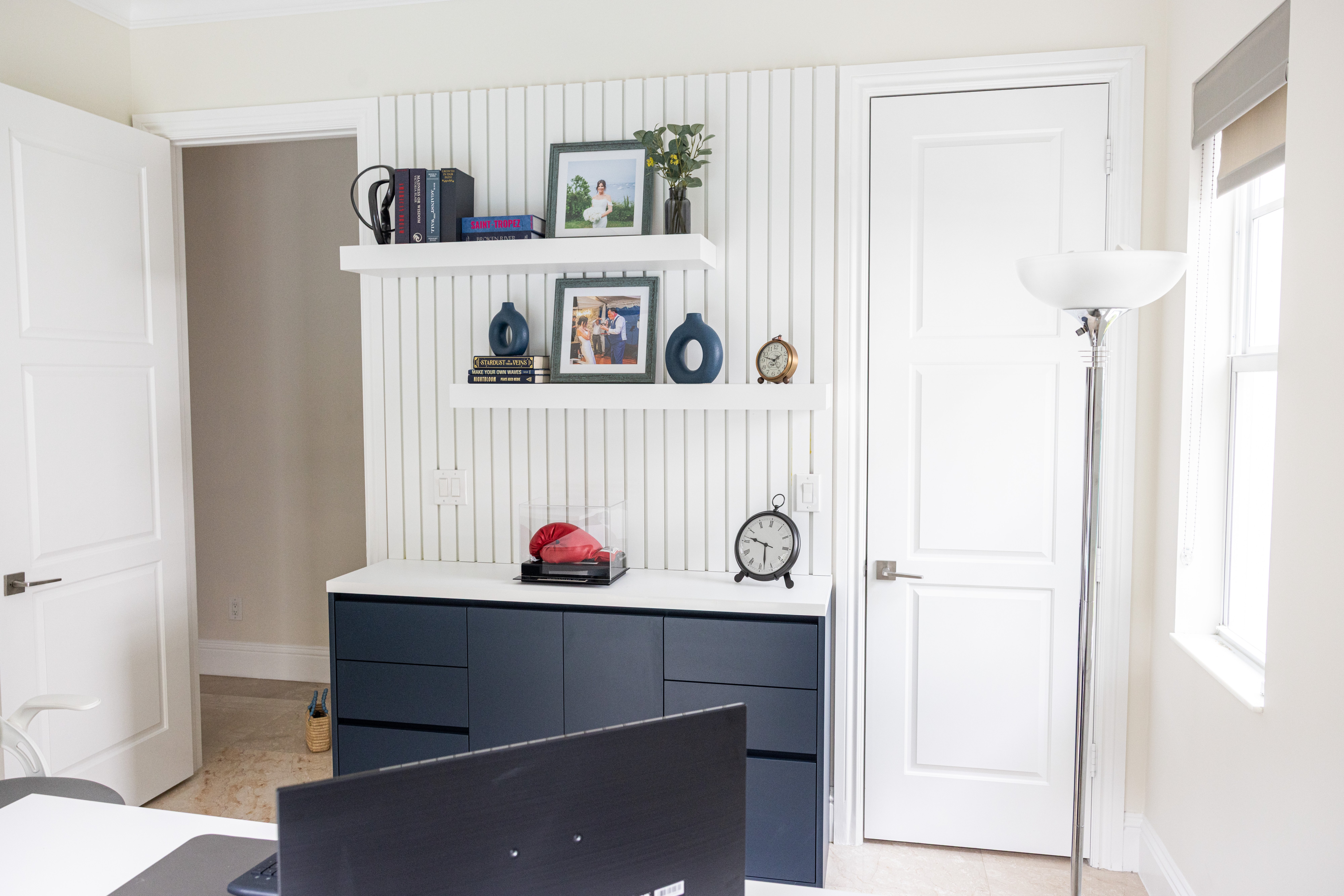 Home office full view with navy built-ins, floating shelves and natural light