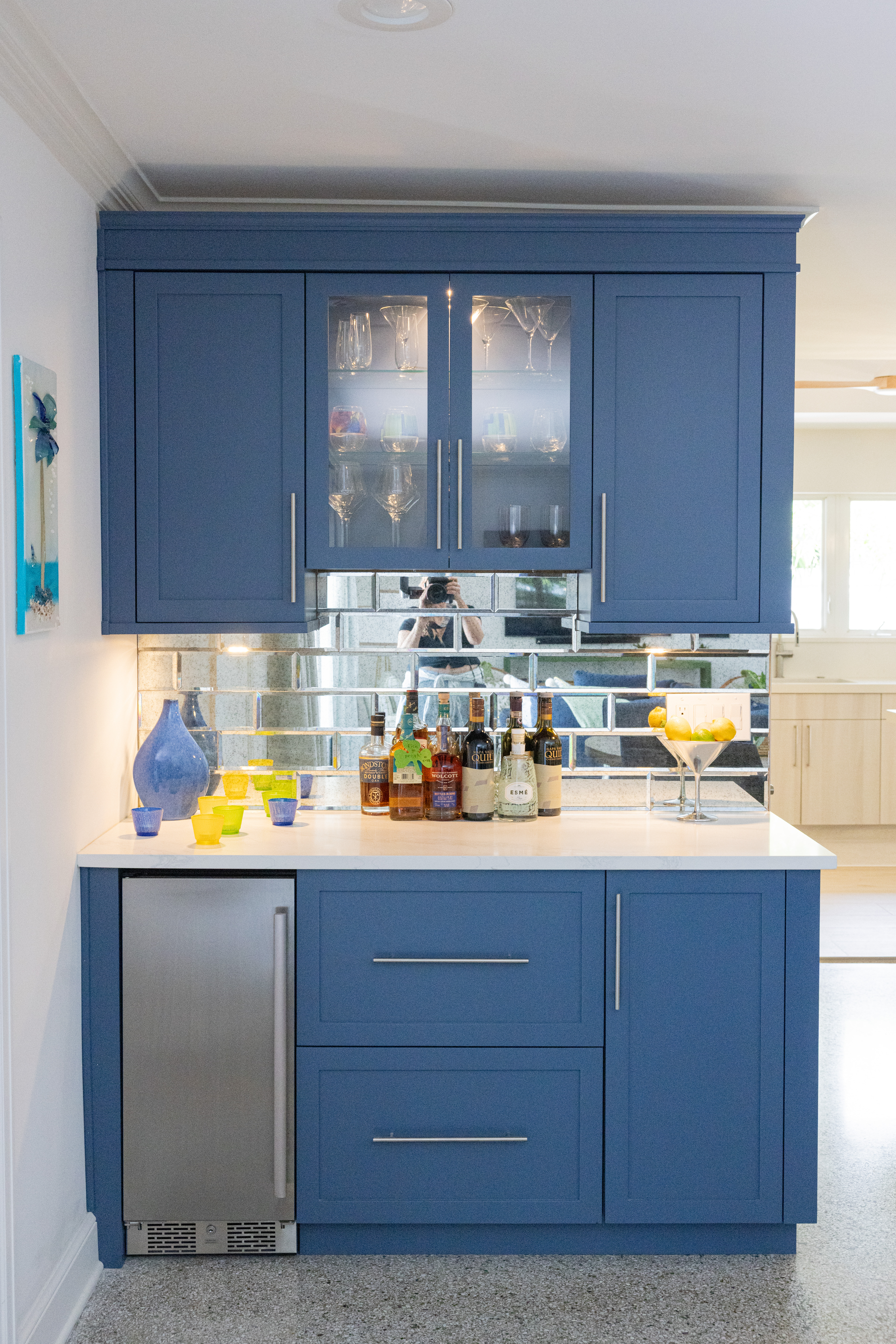 Navy blue bar cabinet with mirrored subway tile backsplash