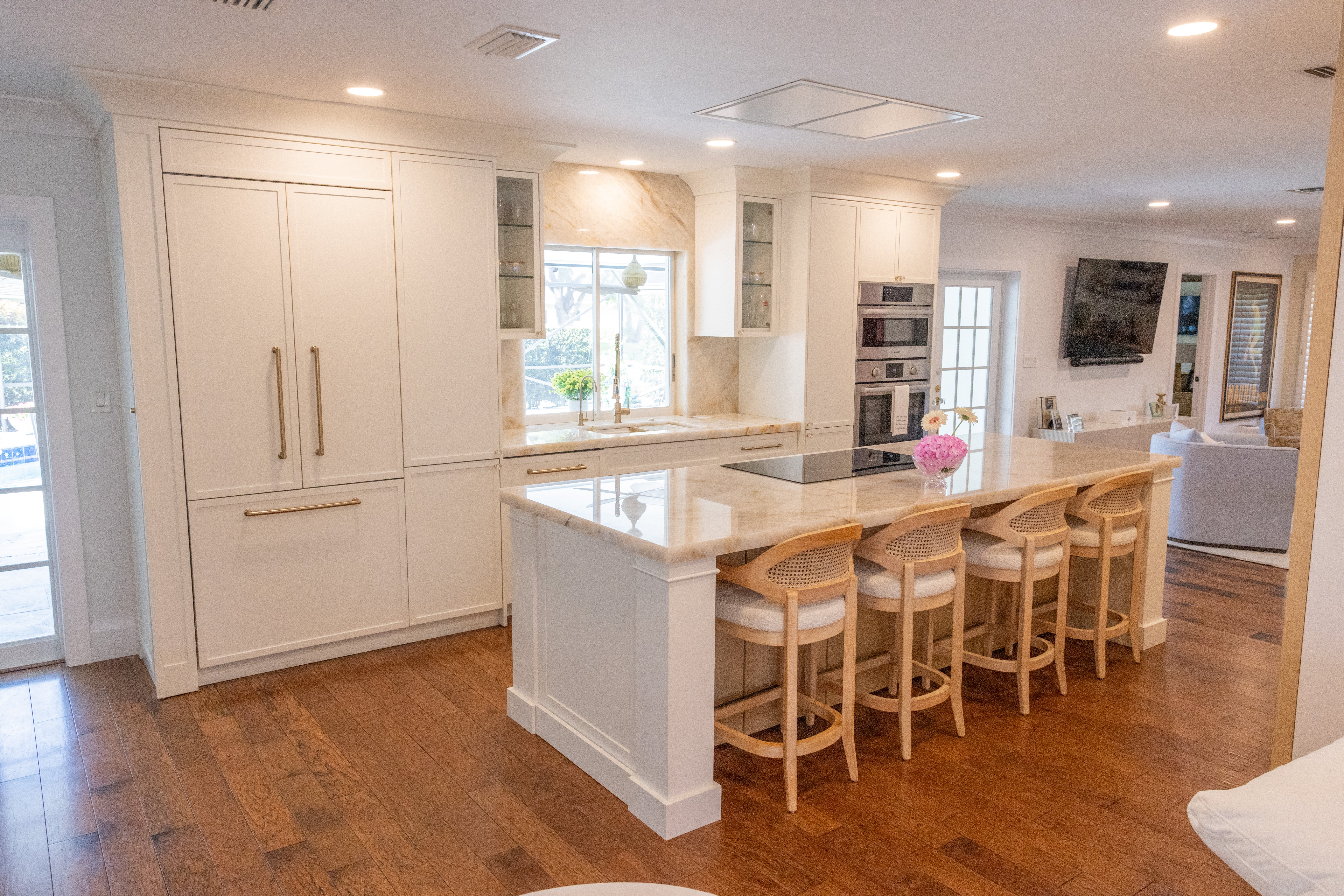 Light wood kitchen with botanical tile backsplash, stainless range and garden window views