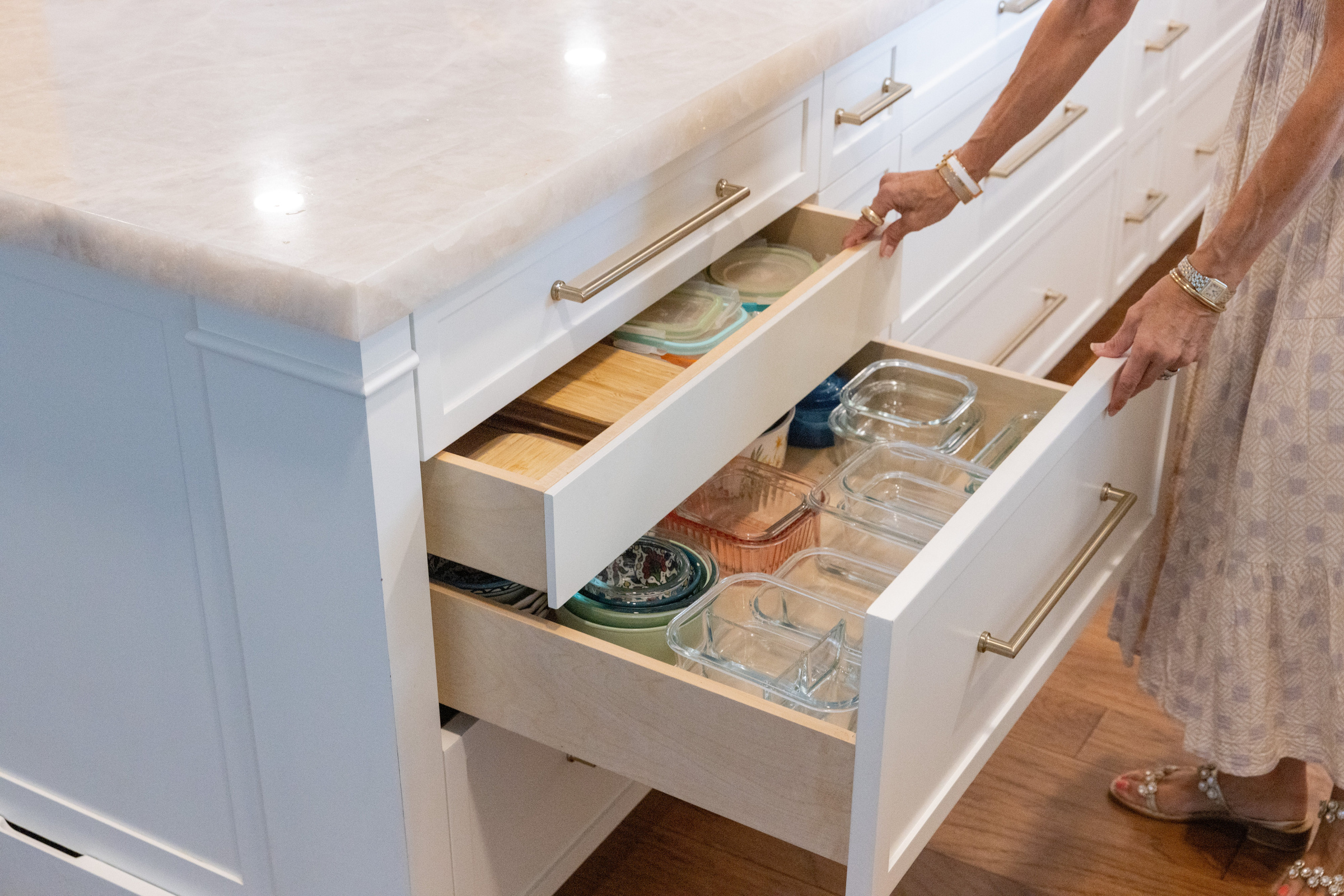 Navy island with rattan counter stools and warm wood cabinetry