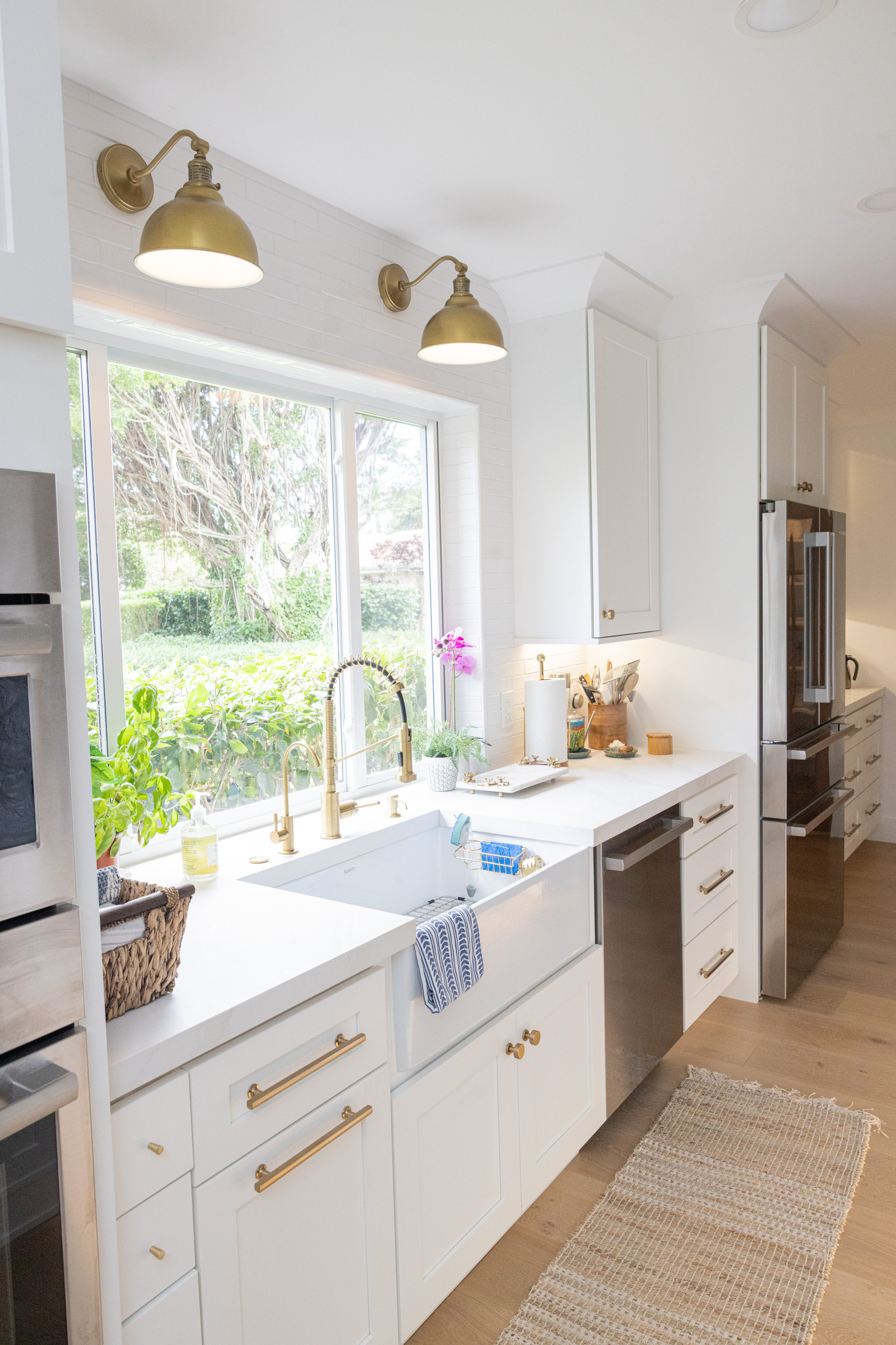 Warm white oak cabinetry with gold fixtures and open display shelving