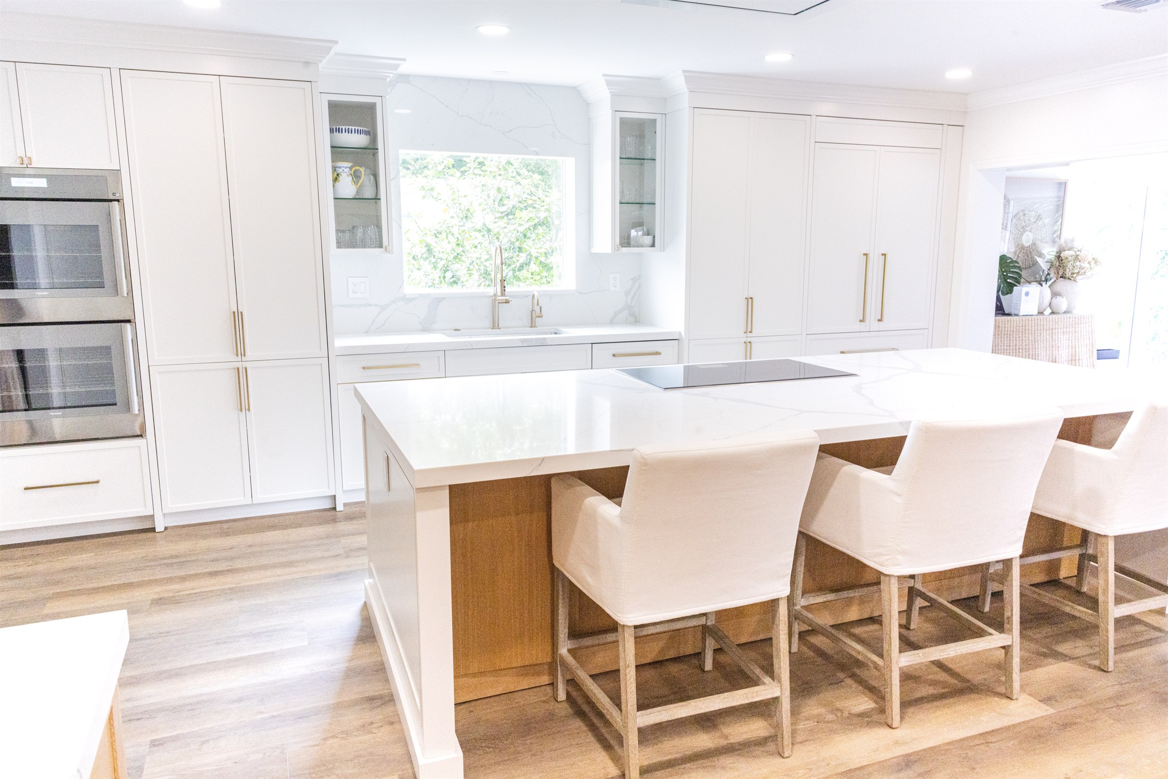 White kitchen wide view with glass-front cabinets and floor-to-ceiling storage