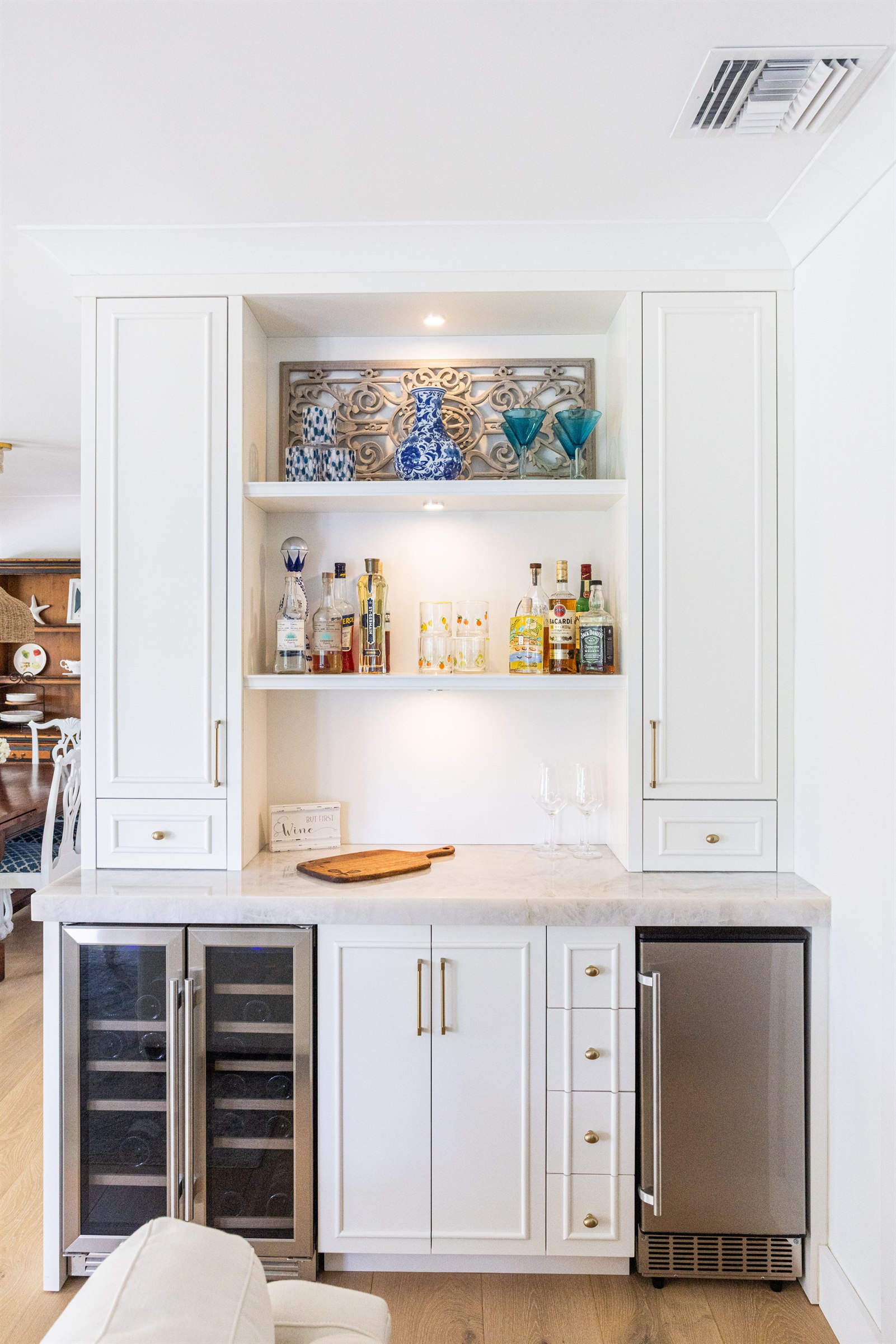 Wet bar nook with dual wine coolers, blue and white vases, and teal martini glasses