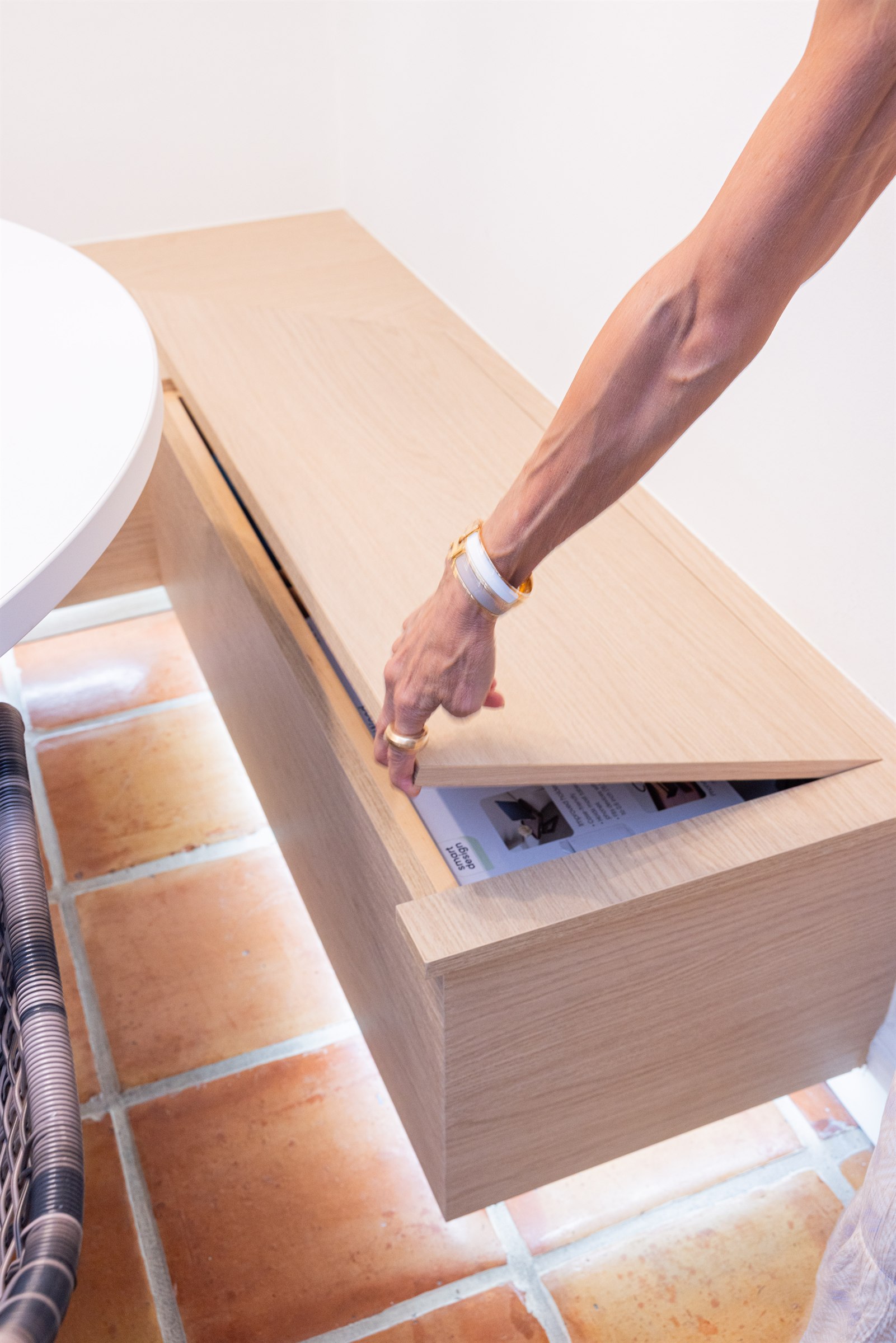 Built-in wood bench with hidden lift-top storage compartment on terracotta tile