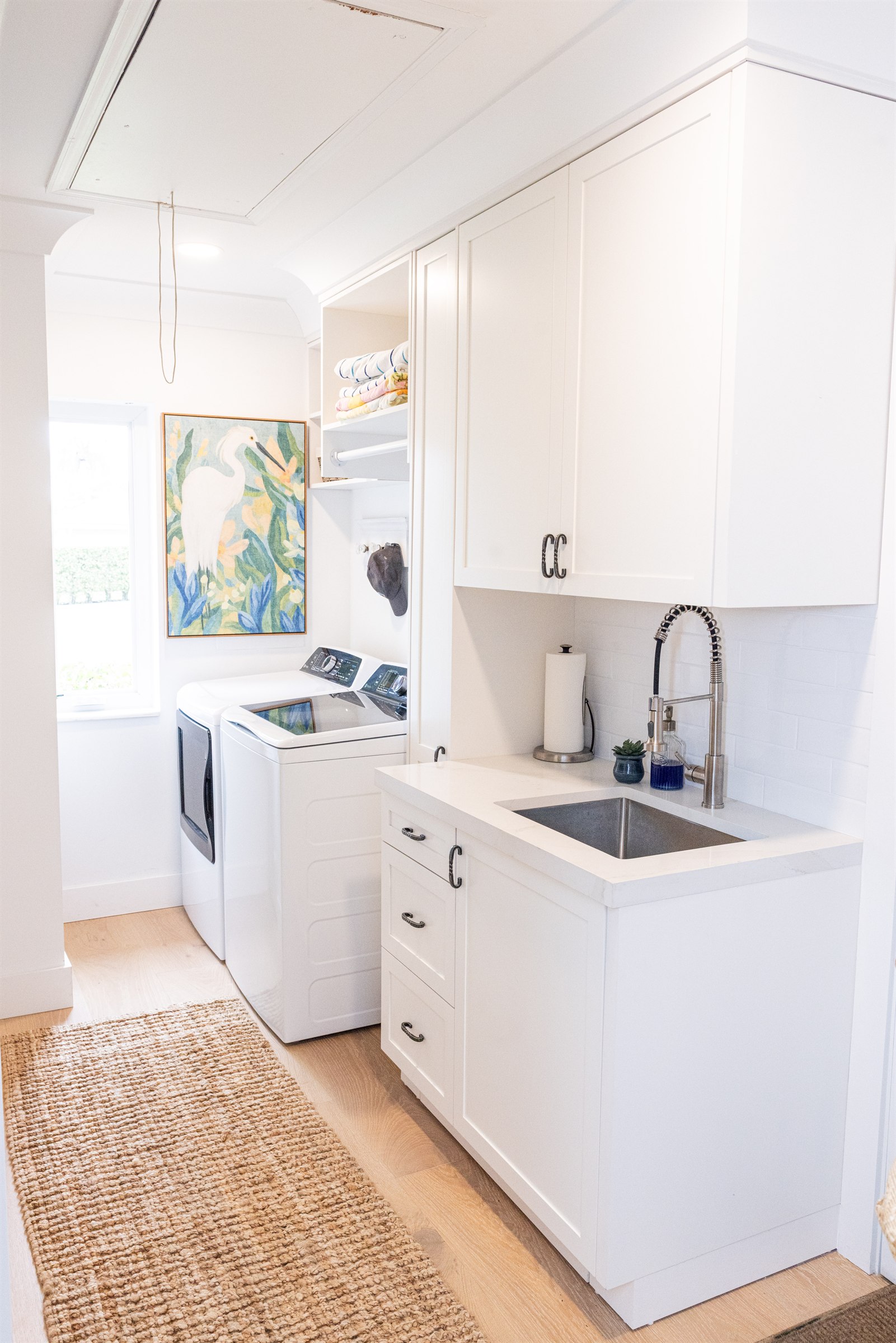 Laundry room with monkey-print wallpaper, marble counter, and built-in cabinetry