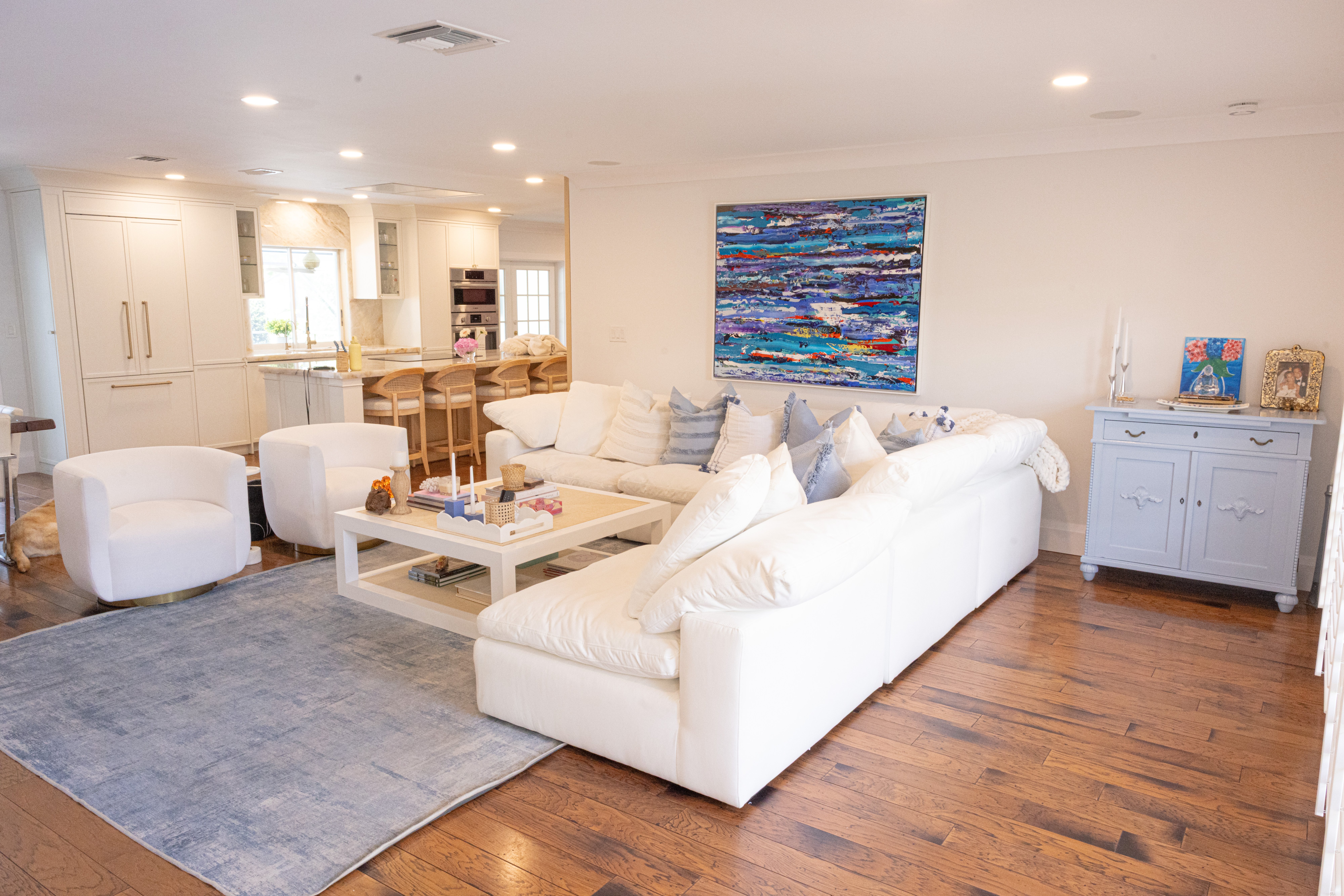 Living room with white sofa, navy zebra-print accent chairs and rattan coffee table