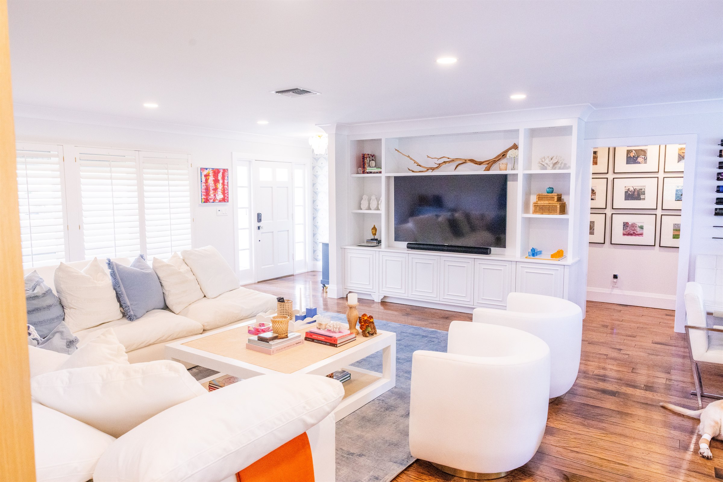 Living room built-in entertainment wall with driftwood branch and gallery wall of family photos