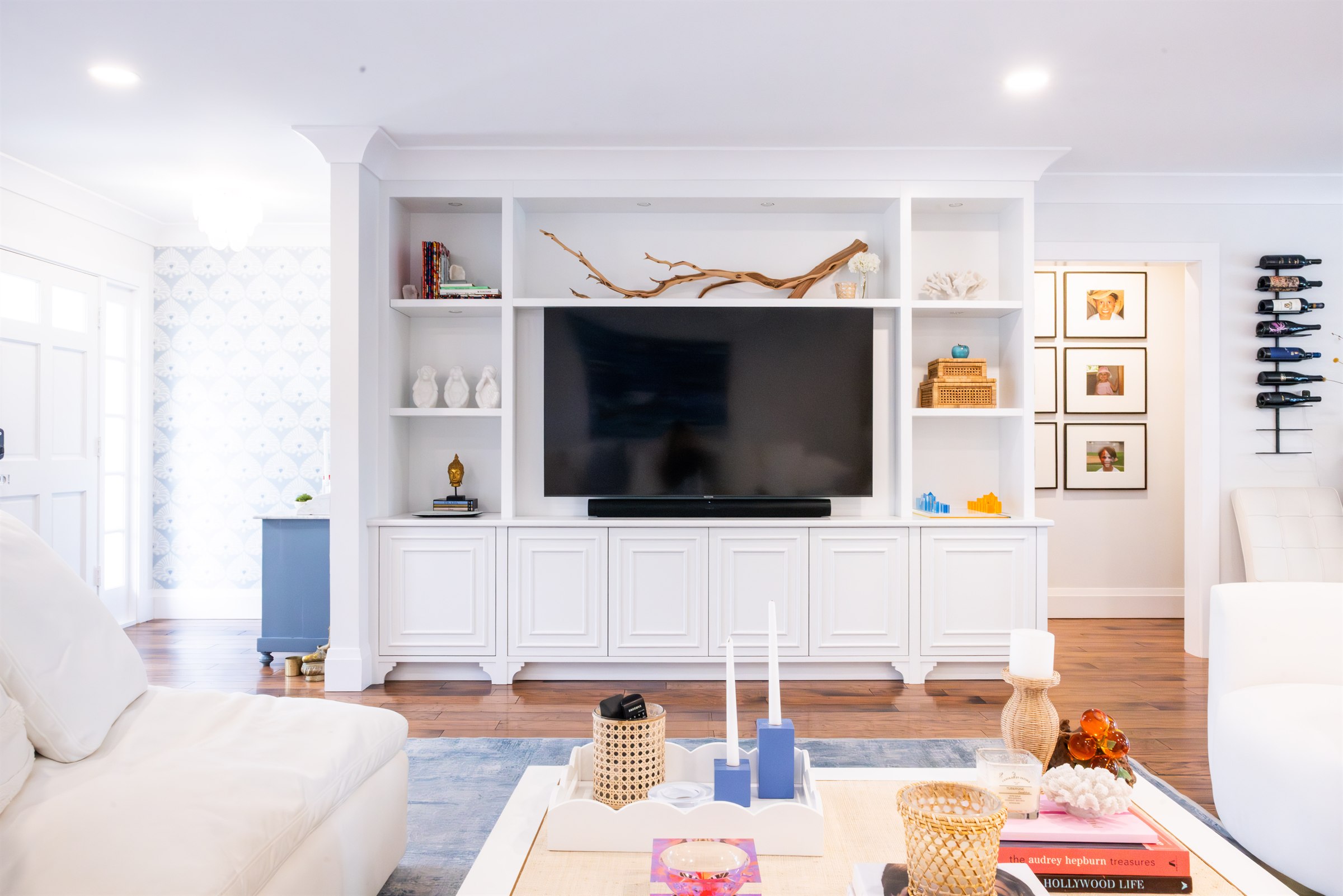 Straight-on view of the built-in entertainment wall with driftwood branch and coral display