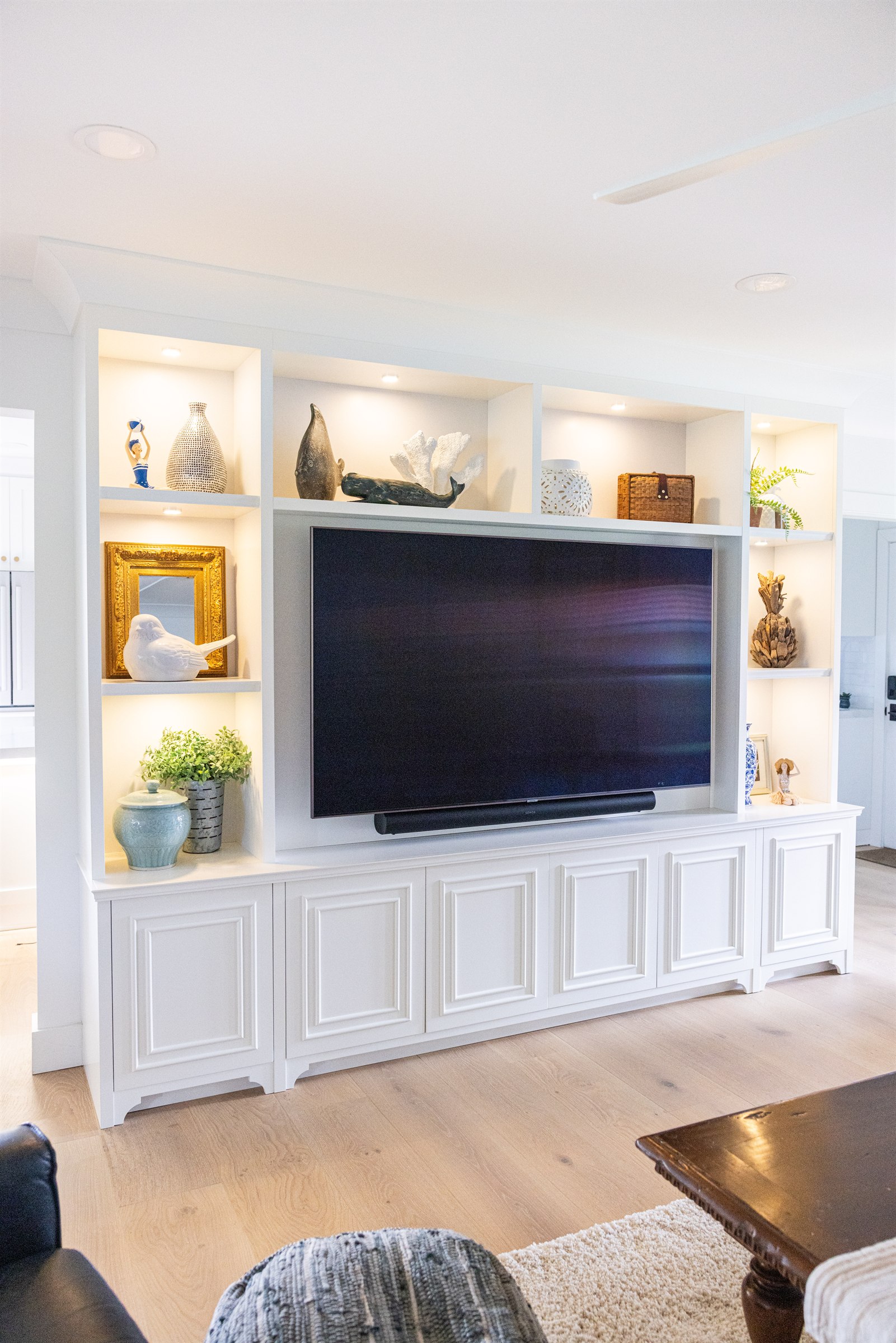 Wide view of the built-in entertainment wall opening to the kitchen and laundry room