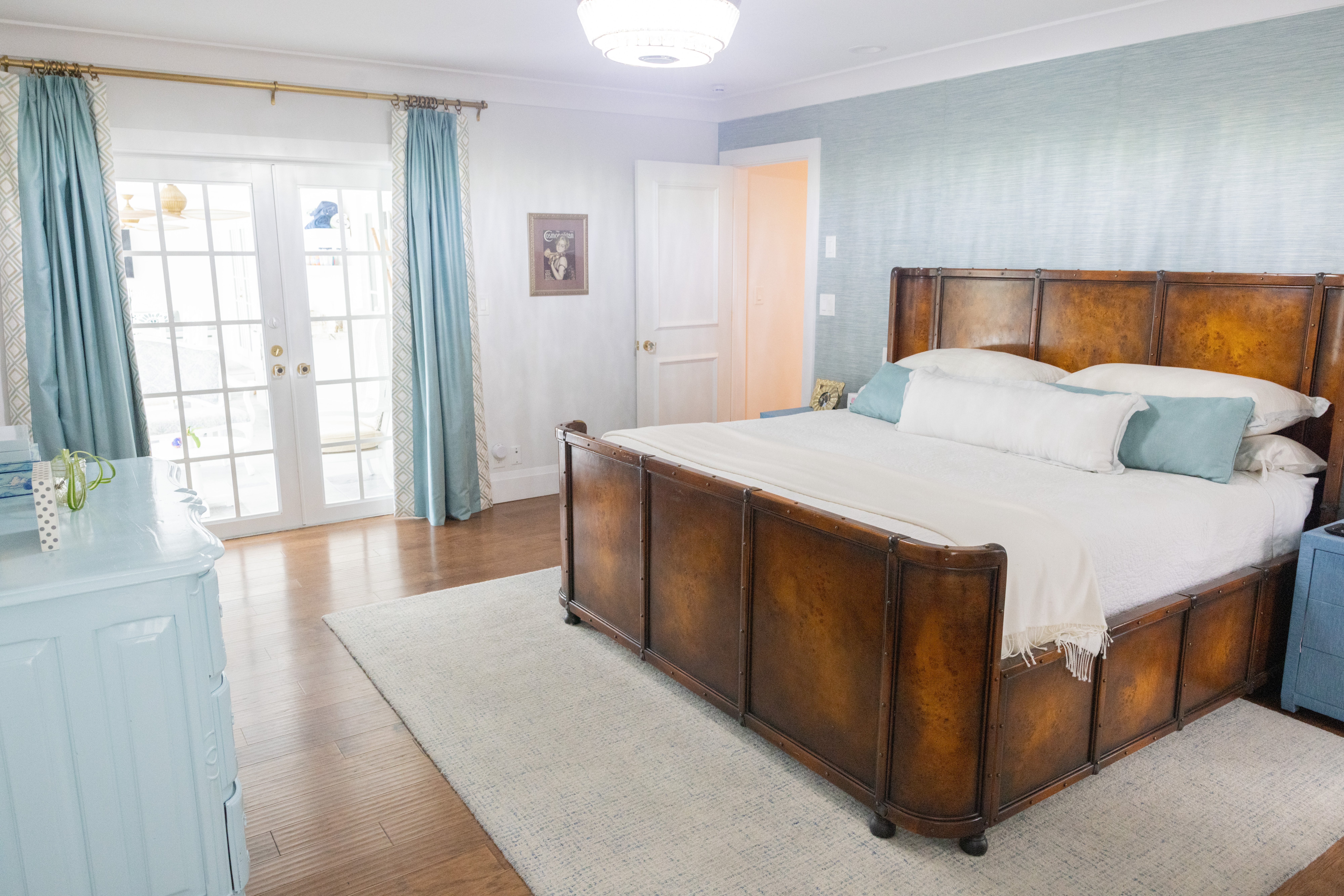 Master bedroom with leather panel bed and teal grasscloth accent wall