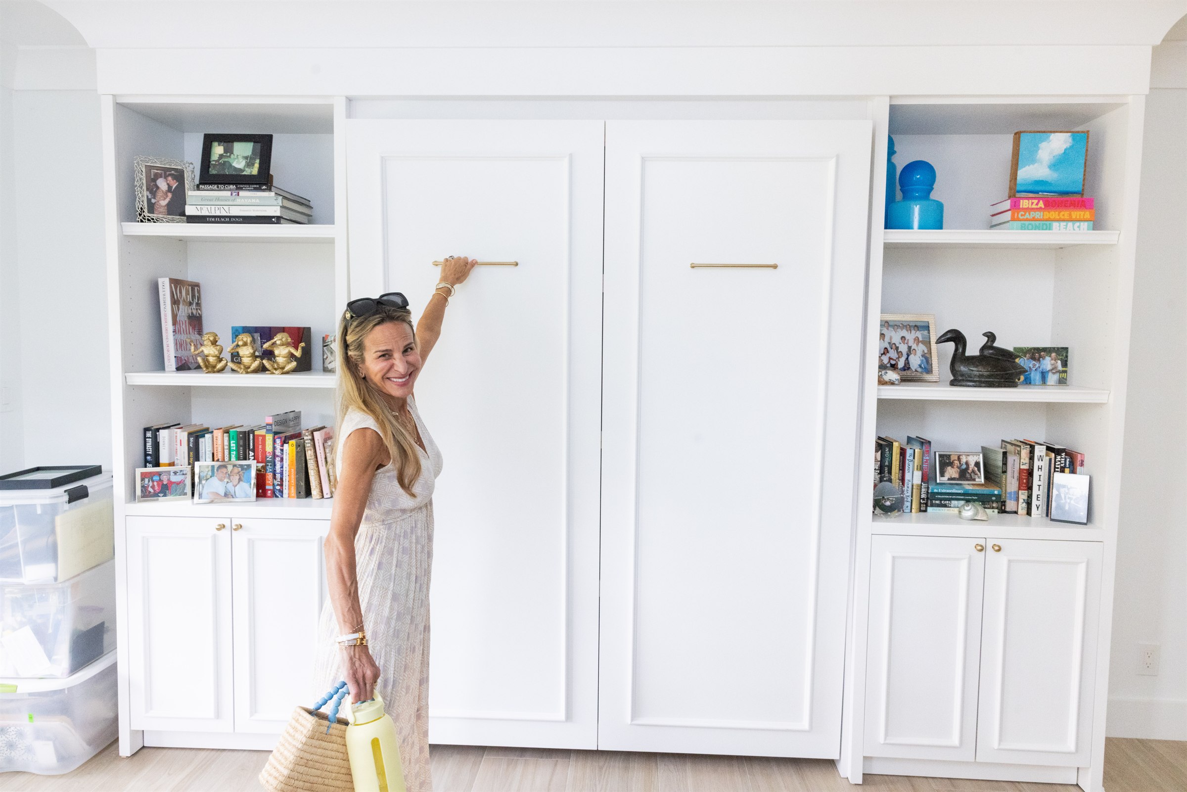 Designer opening the Murphy bed cabinet doors to reveal the bookshelves and bed inside