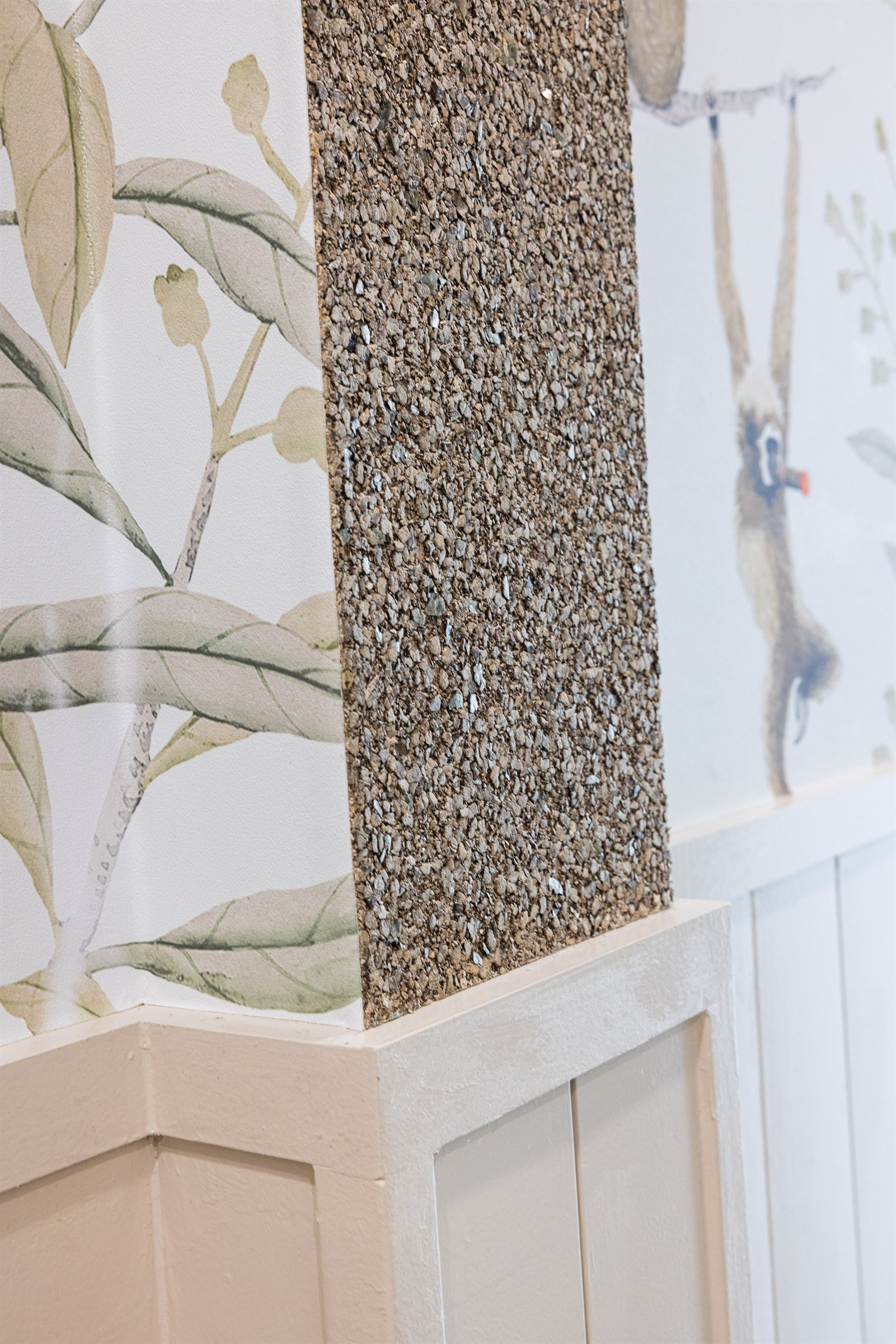 Detail of a chrome toilet paper holder against a textured plaster wall